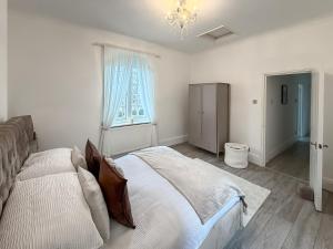 a bedroom with a bed and a window and a chandelier at Joss Bay Days in Broadstairs +8 photos