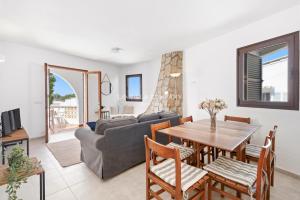 a living room with a table and a couch at Villa FLEUR in Cala en Porter