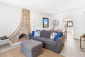 a living room with a couch and a fireplace at Villa FLEUR in Cala en Porter