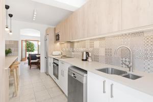 a kitchen with a sink and a counter top at Villa FLEUR in Cala en Porter +19 photos