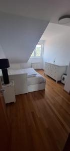 a white bedroom with a bed and a wooden floor at A&M Real Estate in Milladoiro