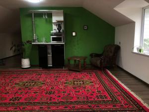 a living room with a red rug and a green wall at Secret Garden in Dushanbe