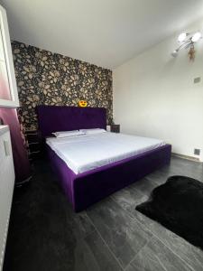 a bedroom with a purple bed in a room at Apartament CC in Drobeta-Turnu Severin