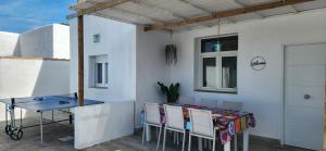 a table and chairs on a patio with a table and a window at Parisito Sancti Petri - Villa amplia con piscina privada in Chiclana de la Frontera