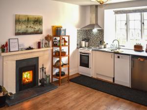 a kitchen with a fireplace and a stove at Little Gubbs in West Buckland