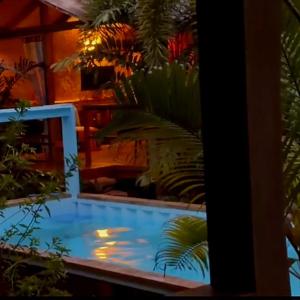 a swimming pool in a room with plants at At Home in Puerto Princesa City