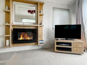 a living room with a fireplace and a flat screen tv at The View in Stranraer