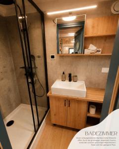 ein Badezimmer mit Waschbecken und Dusche in der Unterkunft Tinyhouse WeserNest in Sandstedt + 8 Fotos
