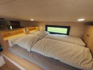 ein großes Bett mitten im Zimmer in der Unterkunft Tinyhouse WeserNest in Sandstedt