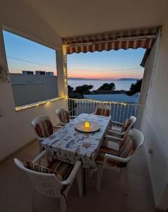 a table with chairs and a candle on a balcony at Tucepi Kamena 57 in Tučepi