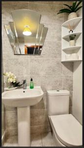 a bathroom with a sink and a toilet and a mirror at Super-King Room Tobermory with shared bathroom in Tobermory