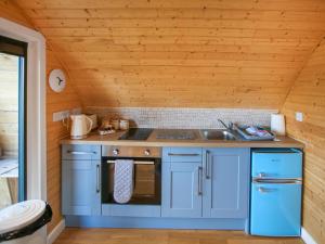 a kitchen with blue cabinets and a sink at Dougie's Pod in Acharacle