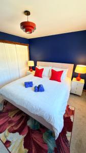 a large white bed with red and blue pillows at Super-King Room Tobermory with shared bathroom in Tobermory +6 photos