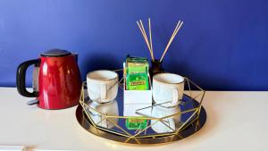 a tray with three coffee mugs and a red mug at Super-King Room Tobermory with shared bathroom in Tobermory