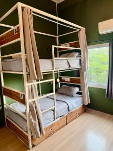 two bunk beds in a room with a window at You Empire Hostel & Bar in Pakse