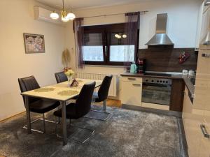 a kitchen with a table and chairs in a room at Apartmani Hrastik 1 in Bihać