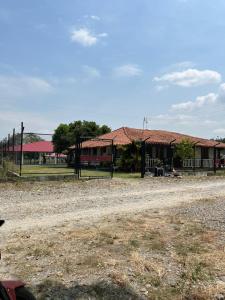 a group of buildings with a dirt road in front at Quinta Campestre Bella Vista in Acacías