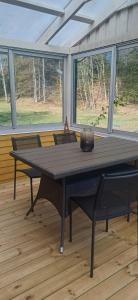 a table in a screened in porch with windows at Black Pearl in Höjaholm