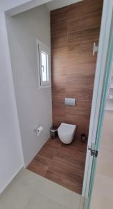 a bathroom with a toilet and a wooden wall at Blue Summer Luxury Suites in Kourouta +34 photos