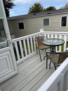 a deck with a table and chairs on a house at Melrose in Lancaster