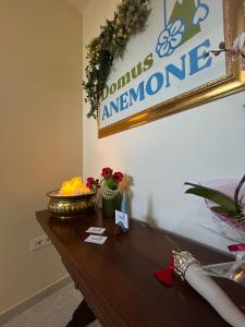 a table with flowers and a sign on the wall at Domus Anemone B&B in Avellino