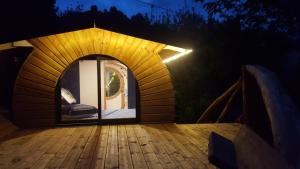 a dome house with a wooden deck at night at Rêve de Plume in Beaumont