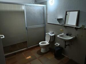a bathroom with a shower and a toilet and a sink at Quinta Campestre Bella Vista in Acacías