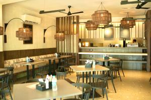 a restaurant with tables and chairs and chandeliers at Hotel Shri Ram Residency in Belgaum