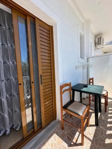 a small table and a chair on a balcony at Vila Riviera in Ksamil
