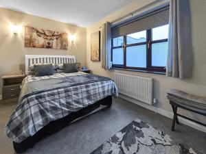 a bedroom with a bed and a window at The Lade in Kilsyth