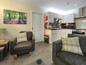 a living room with two chairs and a kitchen at The Lade in Kilsyth