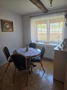a dining room with a table and chairs and a window at Apartmán na statku NH Stables in Nýřany