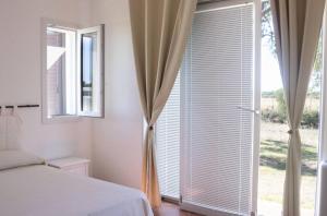 a bedroom with a bed and a large window at Villa Selas in Leporano Marina