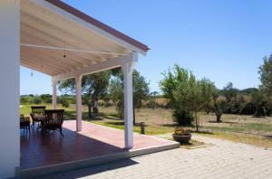 a pavilion with a table and chairs on a patio at Villa Selas in Leporano Marina