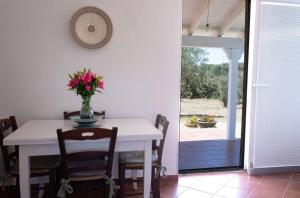 a dining room table with a vase of flowers on it at Villa Selas in Leporano Marina +9 photos