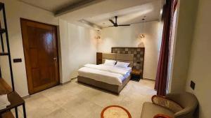 a bedroom with a bed and a door in it at Yes Hotel By The Ganges Rishikesh in Rishīkesh