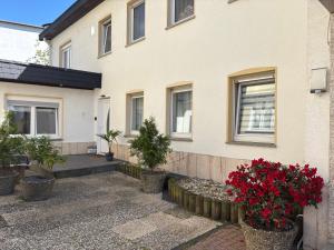a house with red flowers in front of it at Ferienwohnung Melanie 300 Meter zur Therme in Bad Ems
