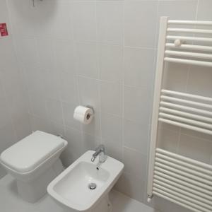 a white bathroom with a toilet and a sink at La Perla sul Trasimeno in San Feliciano