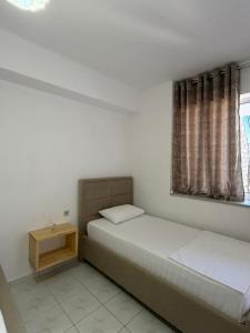 a bedroom with two beds and a window at Villa Mirjan in Sarandë
