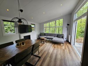 a living room with a table and a couch at Boshuis de Boompjes in Doornspijk