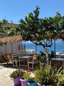 a patio with tables and chairs and a tree at Villa Mirjan in Sarandë