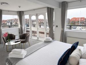 a bedroom with a large bed and a table with chairs at Boathouse Hotel in Hythe