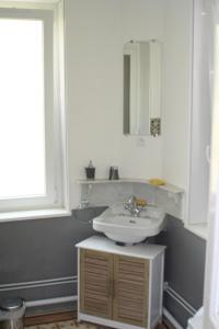 a white bathroom with a sink and a mirror at Manoir de la Saône in Seurre +1 photo