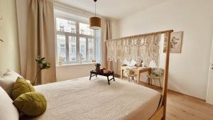 ein Schlafzimmer mit einem Bett, einem Fenster und einem Tisch in der Unterkunft SERVUS HOMES Schönbrunn I Top-Lage & Metro in Wien