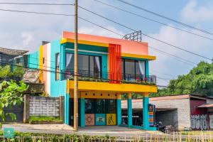 a colorful building with a balcony in front of it at INSTAY Hotel Dieng Chill Serenity in Garung