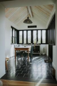 a dining room with a table and chairs and windows at L'envol des oies in Braives