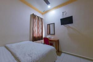 a bedroom with a bed and a desk and a television at SMC Hotel Alam Avenue in Shah Alam