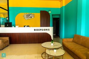 a lobby with two tables in front of a reception desk at INSTAY Hotel Dieng Chill Serenity in Garung +18 photos