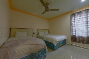 a bedroom with two beds and a ceiling fan at SMC Hotel Alam Avenue in Shah Alam