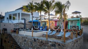 ein Resort mit Pool, Liegestühlen und Palmen in der Unterkunft Beach Front Lux Containers in La Ventana